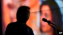 FILE - Republican presidential nominee former President Donald Trump watches as a video showing Democratic presidential nominee Vice President Kamala Harris plays as he speaks during a campaign rally in Latrobe, Pennsylvania, Oct. 19, 2024.