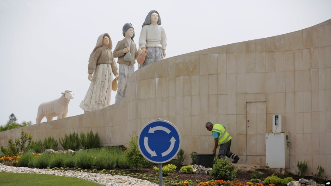 A gardener tends to flowers on a roundabout underneath a statue of the three shepherd children who say they saw visions of the Virgin Mary 100 years ago, in Fatima, Portugal, May 4, 2017. 