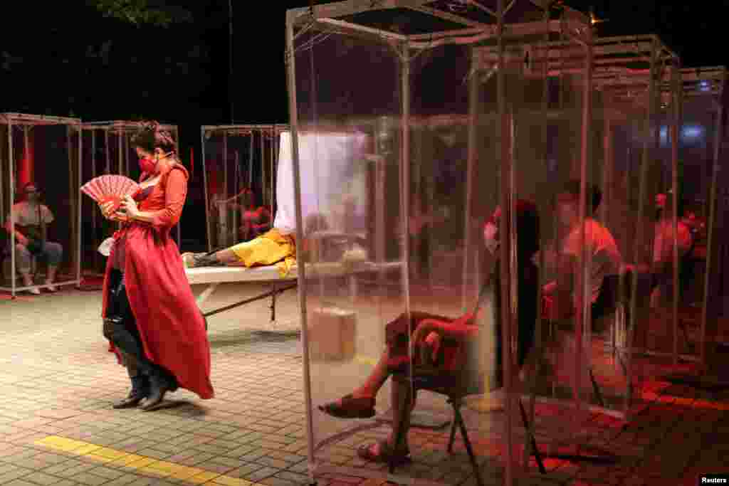 Spectators keep social distance inside individual plastic cabins as they watch the play &quot;Volpone Protocol&quot; staged by Bendita Trupe during the coronavirus outbreak, in Sao Paulo, Brazil, Oct. 28, 2020.