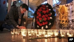 A man lights a candle at the Moskovsky railway station in St.Petersburg, Russia to commemorate the victims of a suicide bombing at Moscow's Domodedovo airport, January 25, 2011