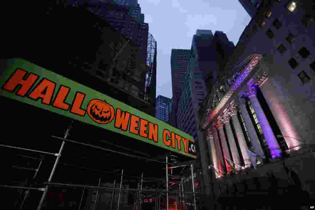 2012年10月31日紐約市的華爾街證券交易所準備開市，這個金融區大部分都還斷電。它的大樓對面掛著慶祝31號萬聖節的標語。挂