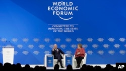 Klaus Schwab, founder and Executive Chairman of the World Economic Forum, talks with German Chancellor Angela Merkel after she addressed the annual meeting of the World Economic Forum in Davos, Switzerland, Jan. 23, 2019. 