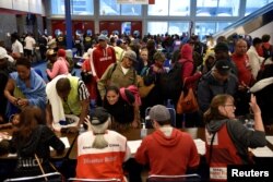 Voluntarios de la Cruz Roja registran a los evacuados en el Centro de Convenciones George R. Brown después de que el Huracán Harvey inundó con lluvias la costa del Golfo de Texas con causando inundaciones generalizadas, en Houston, Texas, el 28 de agosto de 2017.