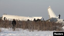 Emergency and security personnel are seen at the site of a plane crash near Almaty, Kazakhstan, Dec. 27, 2019. 