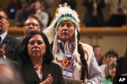 Lee Juan Tyler of Idaho and other audience members wait for the arrival of President Barack Obama to speak at the 2015 White House Tribal Nations Conference, Nov. 5, 2015.