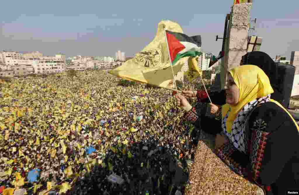 Women wave Palestinian (front) and Fatah flags during a rally marking the 48th anniversary of the founding of the Fatah movement, in Gaza City, January 4, 2013. 