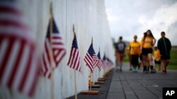 Visitors to the Flight 93 National Memorial pauses at the Wall of Names containing the names of the 40 passengers and crew of United Flight 93 that were killed in this field on Sept. 11, 2001, on Thursday, May 31, 2018. Later this year, the remaining wreckage of Flight 93 will be returned to the Flight 93 National Memorial to be buried in the restricted access zone, in the woods beyond the Wall of Names marked by a giant boulder, where they will not be accessible to the public or media. 