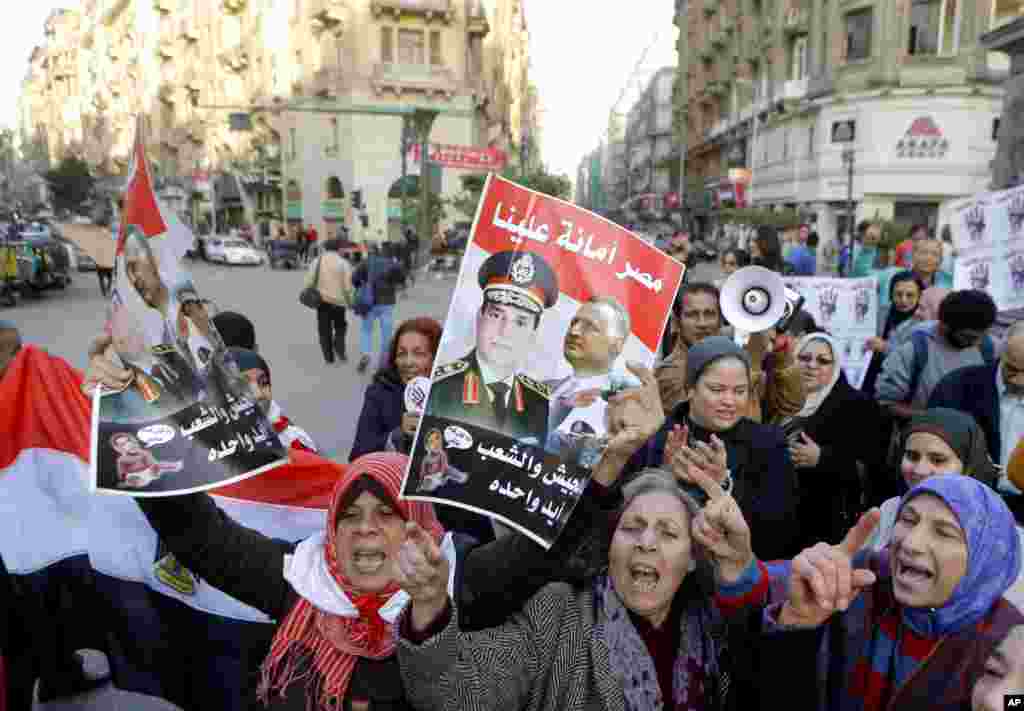 Activists shout anti-terrorism slogans as they hold posters with Arabic slogans that read, &quot;Egypt is entrusted to us. The army and people are one hand,&quot; during a rally in Cairo, Dec. 26, 2013.