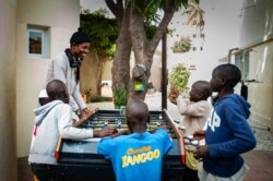 Talibés who were abused by their teachers play with Alassane Diagne, a coordinator at their shelter, Dec. 12, 2019, in Dakar, Senegal. (Annika Hammerschlag/VOA)