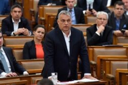 FILE - Hungarian Prime Minister Viktor Orban replies to an oppositional MP during a question and answer session of the Parliament in Budapest, Hungary, March 30, 2020.