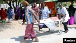 Des secours évacuent les victimes de l'attentat, dans le quartier de Hodan, à Mogadiscio, le 15 octobre 2017.