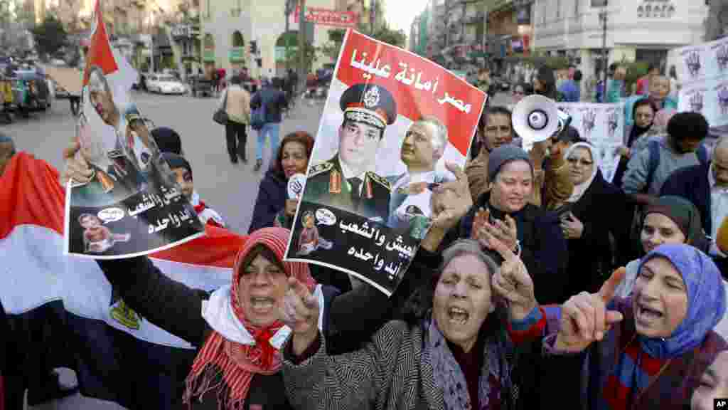 Activists shout anti-terrorism slogans as they hold posters with Arabic slogans that read, &quot;Egypt is entrusted to us. The army and people are one hand,&quot; during a rally in Cairo, Dec. 26, 2013.