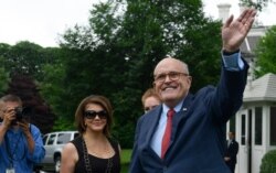 FILE - President Donald Trump's lawyer Rudy Giuliani waves as he attends the White House Sports and Fitness Day event on the South Lawn of the White House in Washington, May 30, 2018.