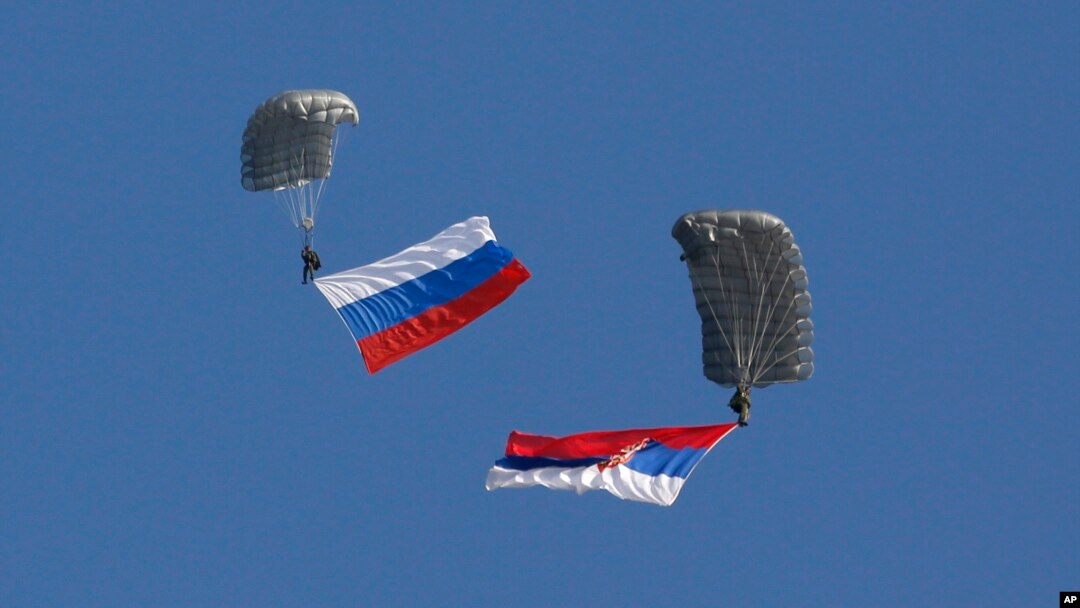 Serbian soldiers parachute from a transport helicopter with Russian, left and Serbian flags during the Russian-Serbian joint antiterrorist exercise Srem 2014, at Nikinci training ground, 60 kilometers west of Belgrade, Serbia, Nov. 14, 2014.