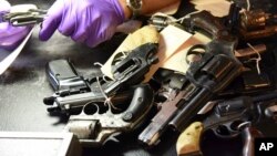 FILE - Weapons are piled on a table after being turned in by residents in a gun buy-back program co-sponsored with the New Life Covenant Church Southeast in the 6th Police District, in this June 2, 2018, photo provided by the Chicago Police Department.