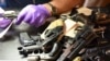 Penguji senjata api forensik memeriksa senjata yang dibawa oleh penduduk dalam program pembelian kembali senjata api di Distrik Polisi ke-6 AS, 2 Juni 2018. (Foto: CPD via AP/dok)