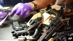 Penguji senjata api forensik memeriksa senjata yang dibawa oleh penduduk dalam program pembelian kembali senjata api di Distrik Polisi ke-6 AS, 2 Juni 2018. (Foto: CPD via AP/dok)