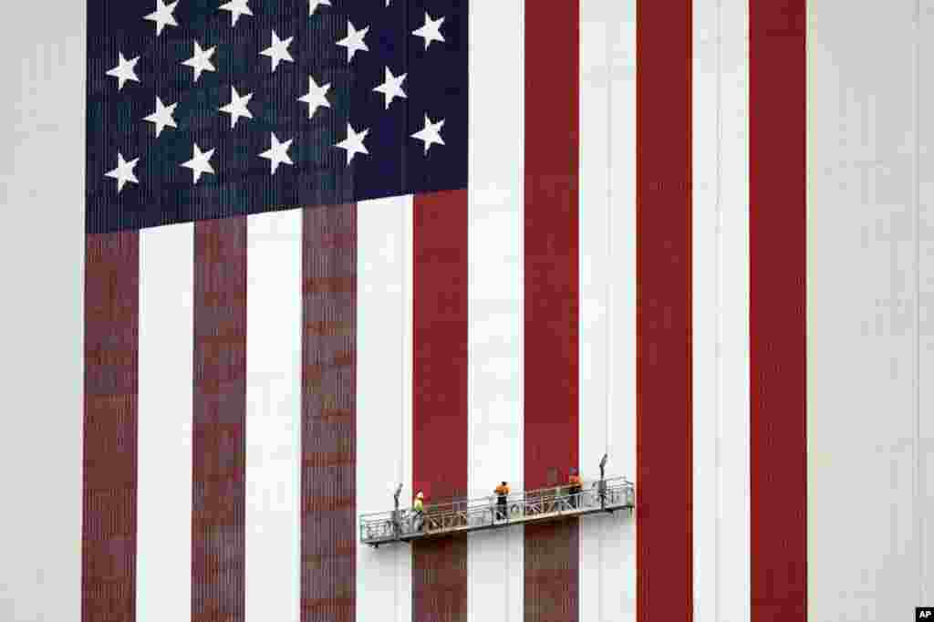 Workers apply fresh paint to the flag on the side of the Vehicle Assembly Building at the Kennedy Space Center in Cape Canaveral, Florida.