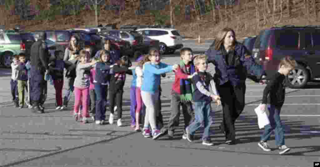 Cảnh s&aacute;t dẫn trẻ em chạy ra từ Trường tiểu học Sandy Hook ở Newtown, Connecticut, sau vụ nổ s&uacute;ng, ng&agrave;y 14/12/2012.