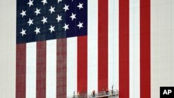 Workers apply fresh paint to the flag on the side of the Vehicle Assembly Building at the Kennedy Space Center in Cape Canaveral, Florida.