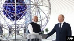 Presidente da Rússia, Vladimir Putin, e o Primeiro-Ministro indiano, Narendra Modi, visitam o pavilhão Atom, um centro de exposições permanente concebido para mostrar o passado e a modernidade da Rússia. Fotografia distribuída pela agência estatal russa Sputnik