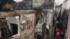 FILE - A person walks past a house that was set ablaze during a gang attack in the Post Marchand neighborhood of Port-au-Prince, Haiti, Dec. 10, 2024.