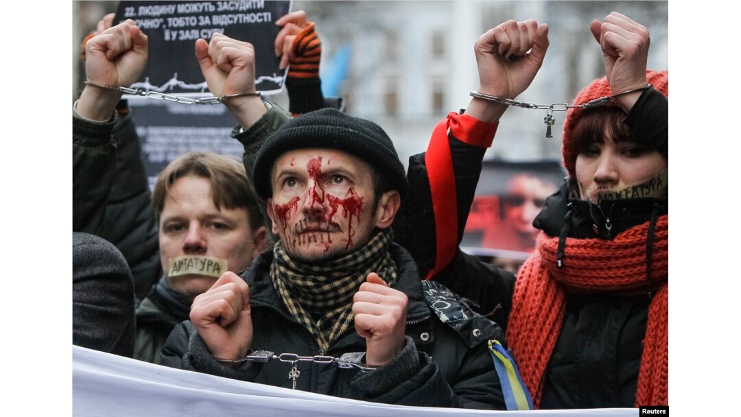 Pro-European integration supporters with taped mouths attend a rally against newly approved laws near the presidential administration in Kyiv, Ukraine, Jan. 17, 2014.