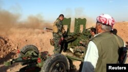 FILE - Kurdish Peshmerga forces fire a weapon during clashes with Islamic State militants in a village east of Mosul, Iraq, May 29, 2016. 