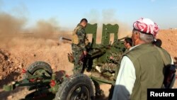 Kurdish Peshmerga forces fire a weapon during clashes with Islamic State militants in a village east of Mosul, Iraq, May 29, 2016. 