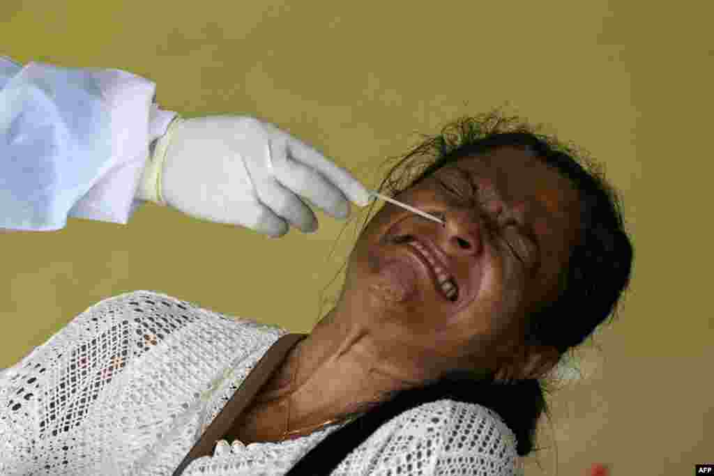 A resident reacts as a health worker collects a swab sample to test for the COVID-19 coronavirus in Colombo.