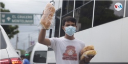Un vendedor ambulante intenta obtener ingresos en medio del tráfico en Managua, Nicaragua. Agosto de 2021. [Fotografía: Houston Castillo Valdo]