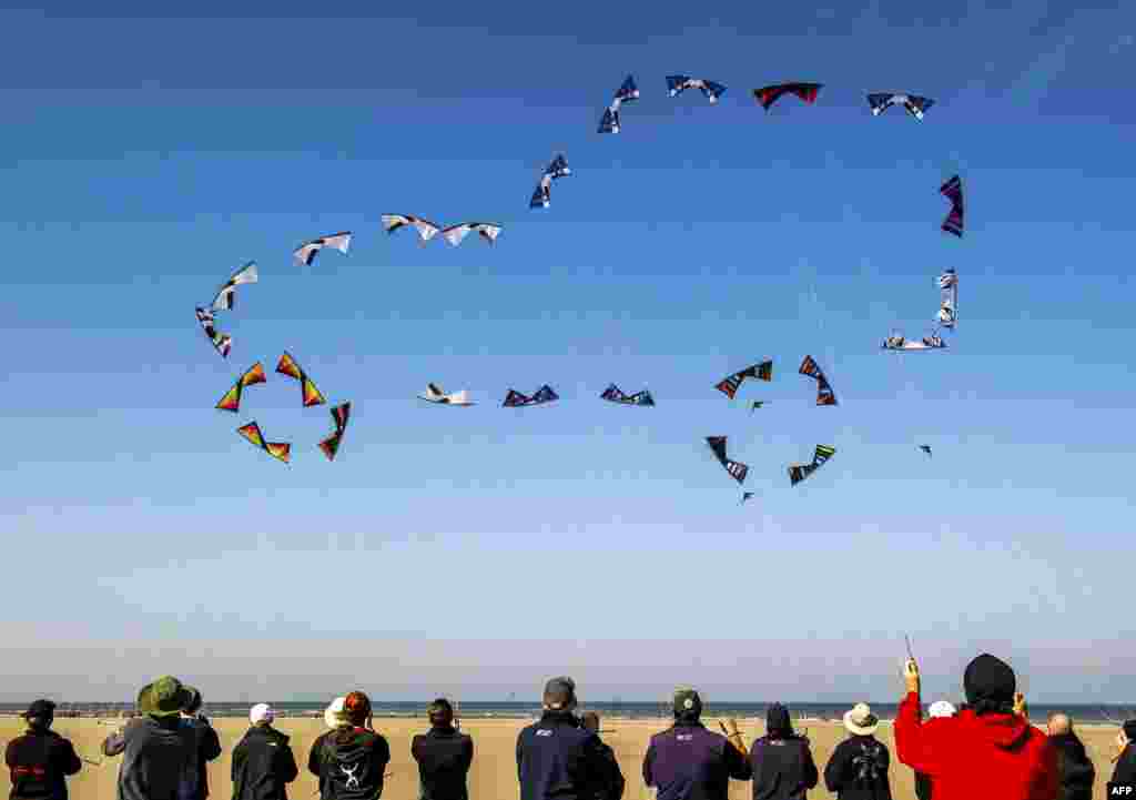Những người thả diều trên bãi biển ở Berck, miền bắc nước Pháp, điều khiển những chiếc diều tạo thành hình một chiếc xe hơi trên bầu trời, trong dịp gặp gỡ giữa những người thả diều quốc tế, kéo dài từ 18 đến 26 tháng 4.