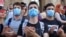 Young opposition demonstrators wearing masks reading "Russia Occupant " gather in front of the Georgian Parliament building in Tbilisi, Georgia, June 21, 2019. 