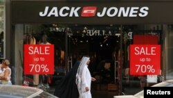 A man walks past a sign advertising a sale in Beirut, Lebanon, Aug. 6, 2018. Business has suffered since the start of the Syrian civil war in 2011.