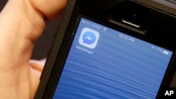 FILE - This mobile phone shows the Facebook Messenger app icon. Users of the app can now play games with it.