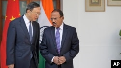 FILE - Indian National Security Adviser Ajit Doval, right, talks with Chinese State Councillor Yang Jiechi before their delegation-level meeting in New Delhi, India, Dec. 22, 2017.