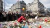 A woman lays flowers on a memorial to victims of the Brussels attacks during a march against hate in Brussels on Sunday, April 17, 2016.