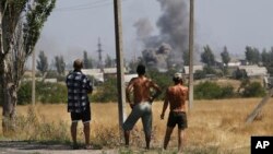 Residente locales observan el cañoneo en el pueblo de Novoazovsk, en el este de Ucrania.