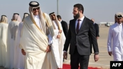 A photo released by the official Syrian Arab News Agency on Jan. 30, 2025, shows Qatar's Emir Sheikh Tamim bin Hamad Al Thani, left, welcomed by Syria's interim president Ahmed al-Sharaa, upon his arrival in Damascus. (AFP PHOTO/HO/SANA) 