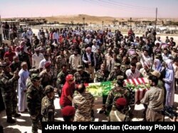 FILE - Yazidi people gather during the burial ceremony of Leland Scott in Sharfadin shrine, Duhok, Iraq, June 21, 2016.