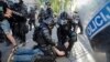FILE - A protester is detained by riot police during an anti-government demonstration in Ljubljana, Slovenia, June 25, 2021. 