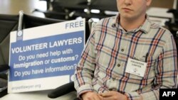 A volunteer waits outside the international arrivals terminal at Seattle-Tacoma International Airport offering legal assistance, March 5, 2017. Volunteers have offered help to international travelers since the original travel ban was announced.