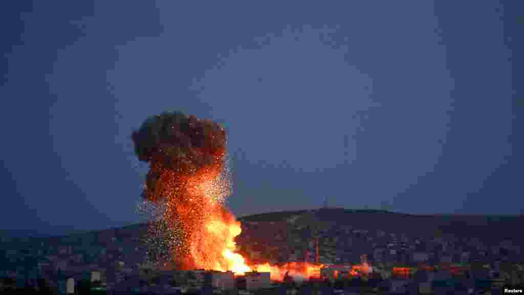 Smoke and flames rise over Syrian town of Kobani after an airstrike, as seen from the Mursitpinar border crossing on the Turkish-Syrian border in the southeastern town of Suruc, Sanliurfa province, Oct. 18, 2014. 