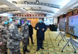 FILE - Chinese President Xi Jinping is briefed about hospital operations, treatment of patients, protection for medical workers and scientific research in Wuhan, ground zero of the coronavirus pandemic, Hubei province, China, March 10, 2020.