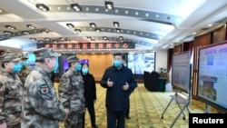 FILE - Chinese President Xi Jinping learns about hospital operations, patient treatment, protection for medical workers and scientific research in Wuhan, the epicenter of the novel coronavirus outbreak, Hubei province, China, March 10, 2020.