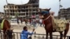 A man holds a horse near damaged buildings during the first day of the Muslim holiday of Eid al-Fitr in Raqqa, Syria, June 5, 2019. 