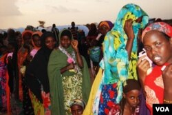 Ibu-ibu dan anak-anak mengantri makan malam di pusat transit pengungsi di Dollo Ado, Ethiopia (26/10).