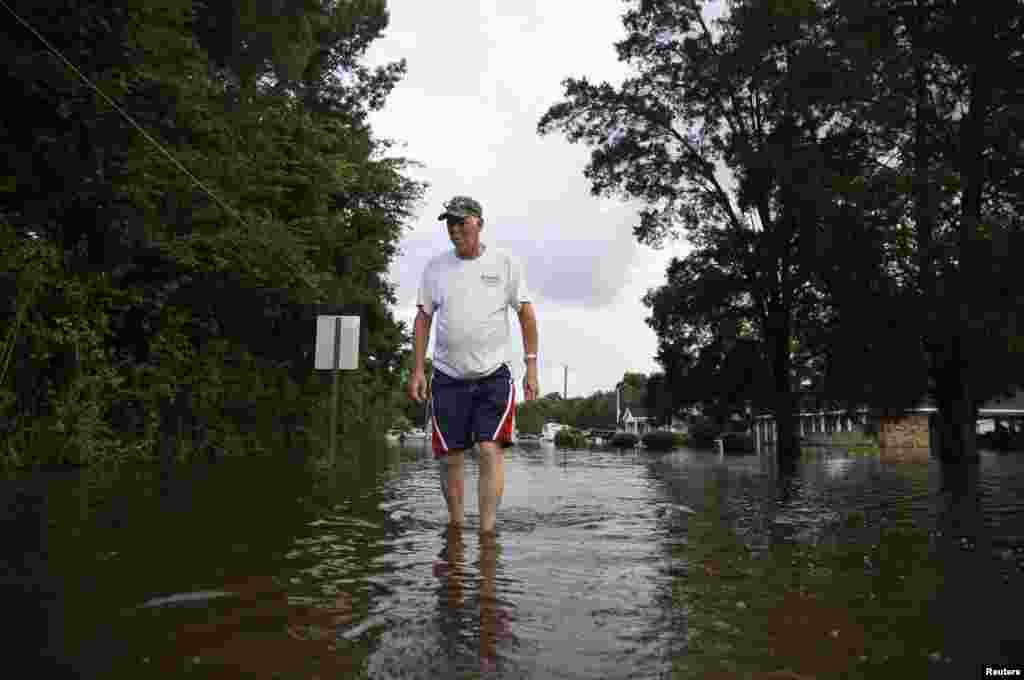 Donald Ezell marche dans une rue inondée où il habite à Sorrento, Louisiane, le 17 août 2016.