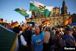 Warga mengibarkan bendera Sachsen selama acara kampanye Jerman (AfD) untuk pemilihan negara bagian Sachsen di Dresden, Jerman, 29 Agustus 2024. (Foto: REUTERS/Lisi Niesner)