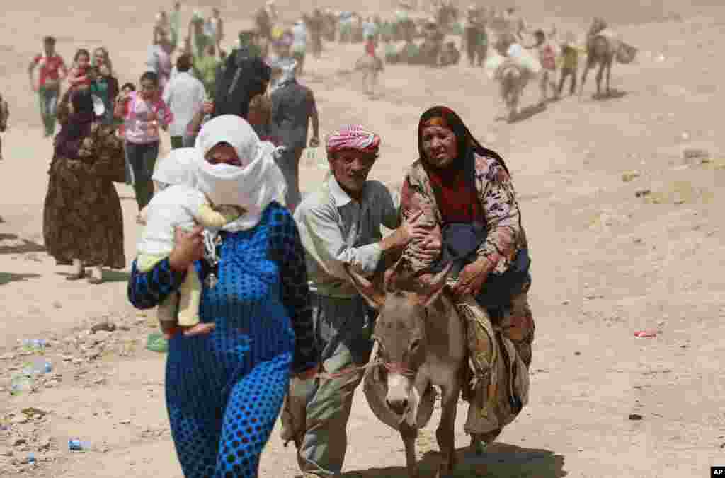 Syrian refugees cross into Iraq at the Peshkhabour border point in Dahuk, 260 miles (430 kilometers) northwest of Baghdad, Iraq, Aug. 20, 2013. 